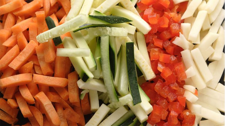 Narezana bučka in korenček na palčke in kockice.