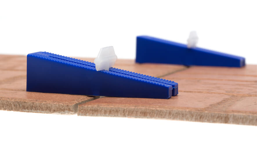 ET_klini in spojke na ploščici od blizu pritrjene spojke in klini na keramičnih ploščicah