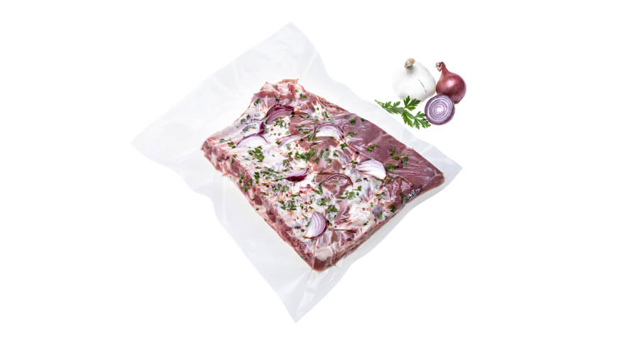 Folija XL_sveža rebra Vakuumsko shranjena začinjena rebra v XL foliji za vakuumiranje na belem ozadju,